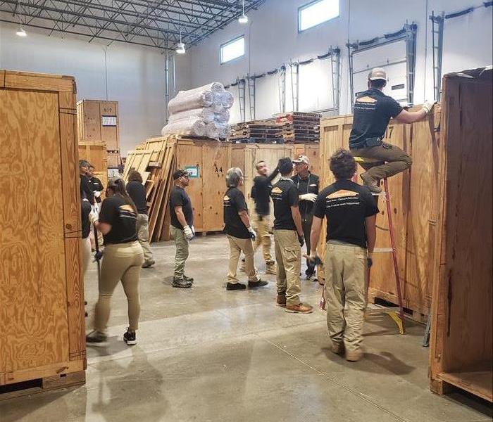 male employees in a warehouse building large box crates