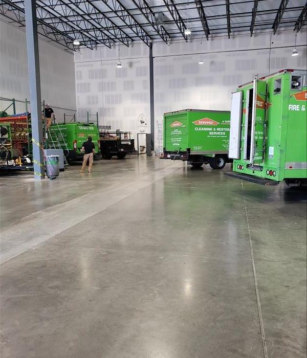 Warehouse space with three green trucks parked